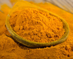 Turmeric powder on a wooden spoon. selective focus
